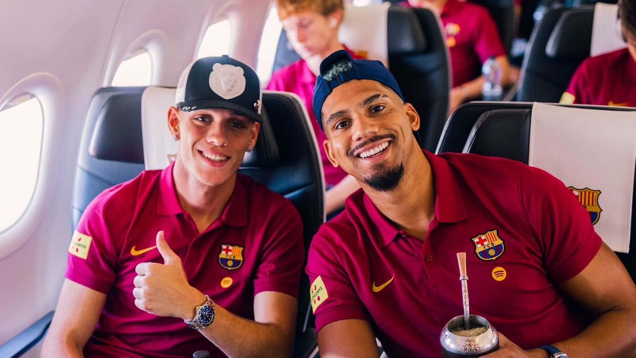 Два игрока Barcelona улыбаются вместе во время полёта в Англию