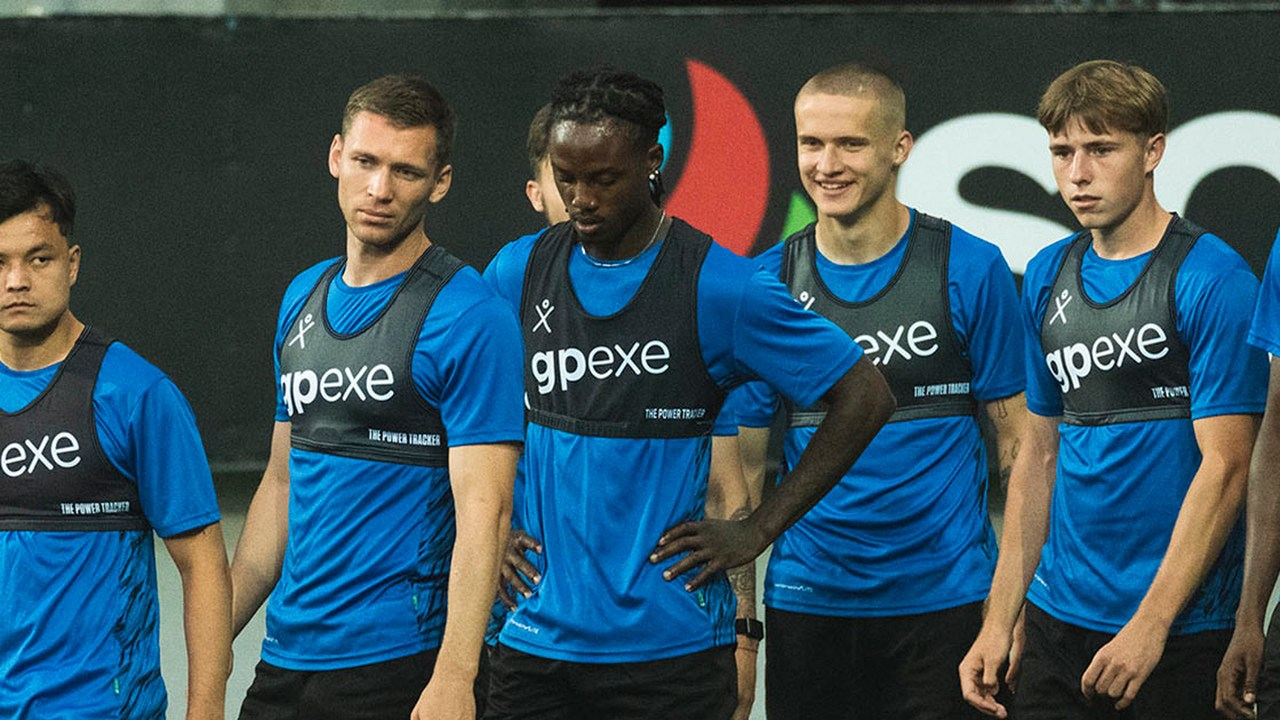 Игроки Dinamo Minsk стоят вместе во время тренировки в Баку