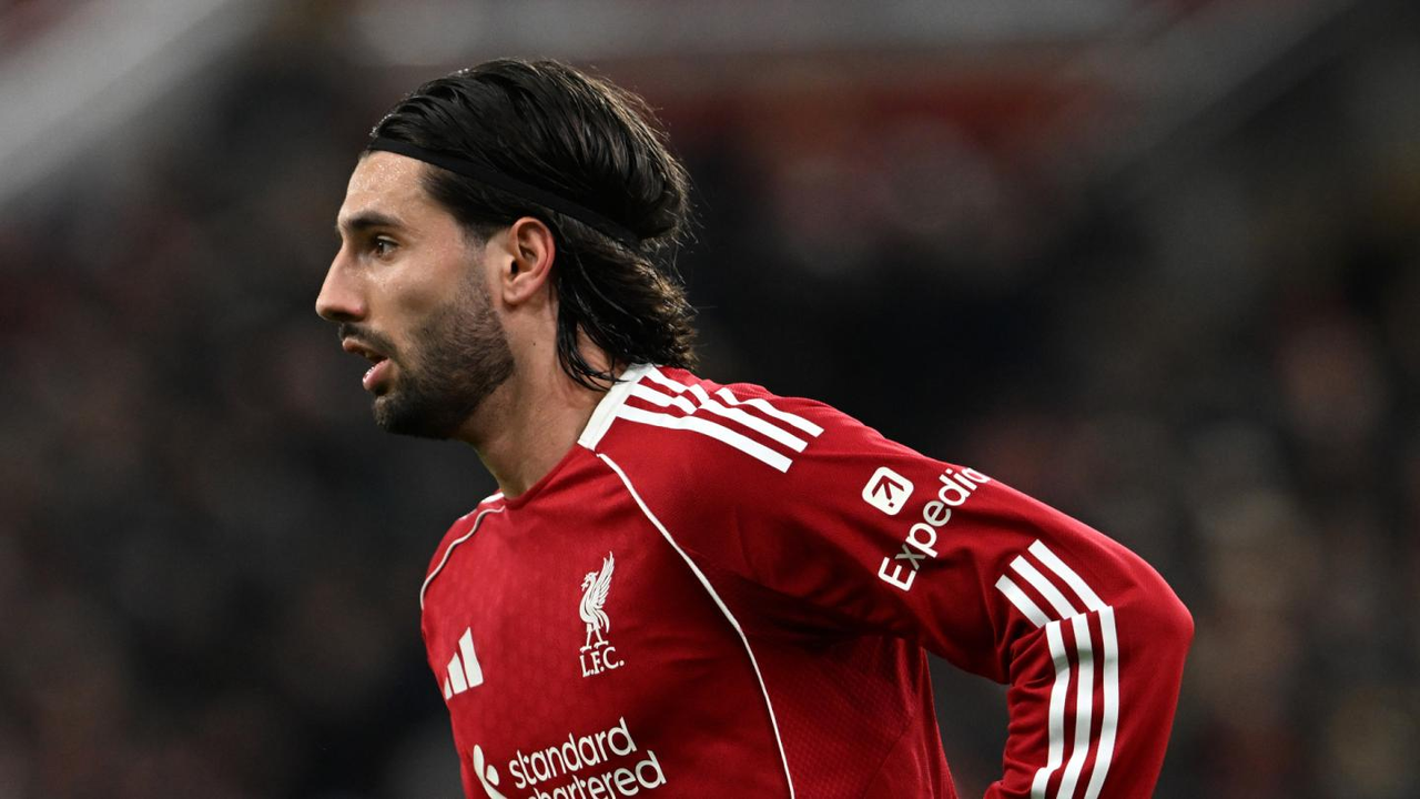 Dominik Szoboszlai de pie en el campo con la equipación roja de local del Liverpool