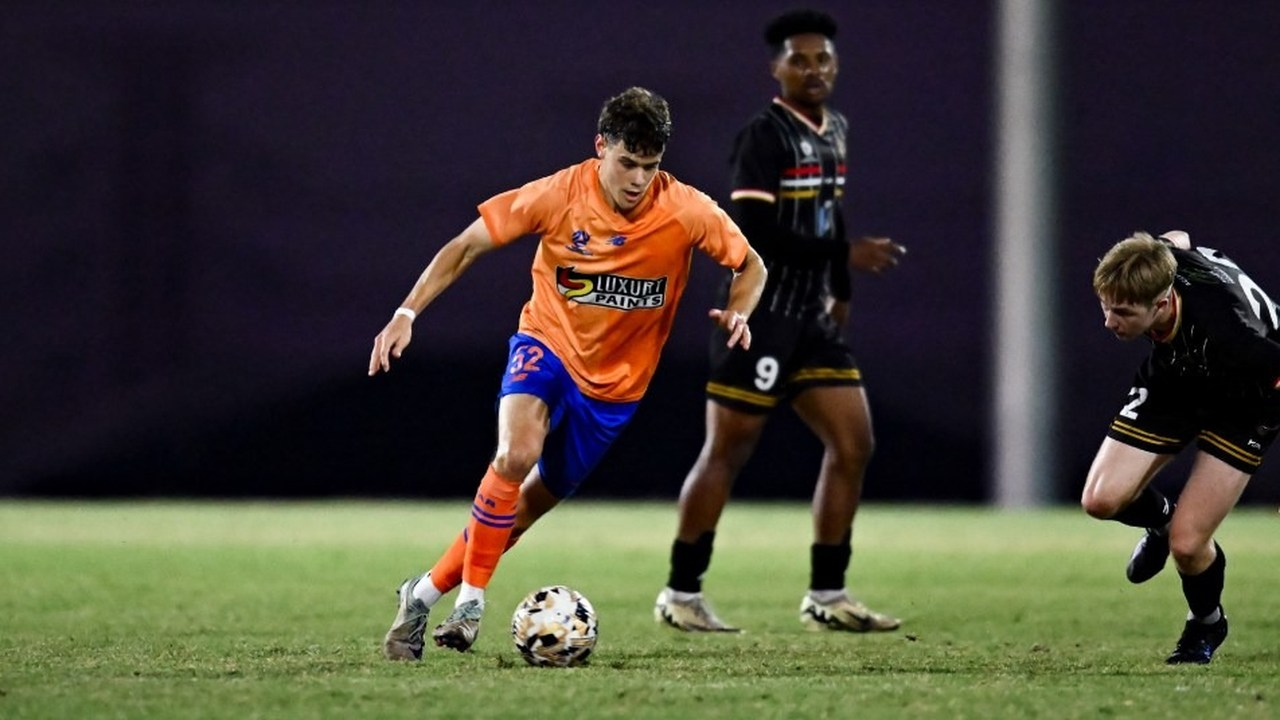 Een Young Roar-speler dribbelt met de bal in een NPL-wedstrijd