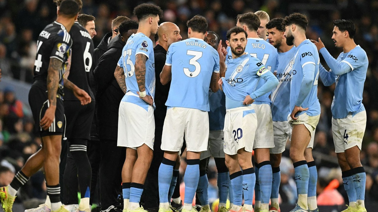 Les joueurs de Manchester City se rassemblent près de la zone technique pendant un arrêt de jeu