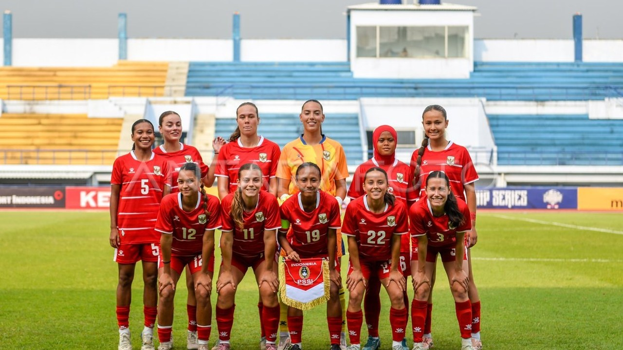 Indonesiske kvindelige fodboldspillere poserer sammen i røde trøjer