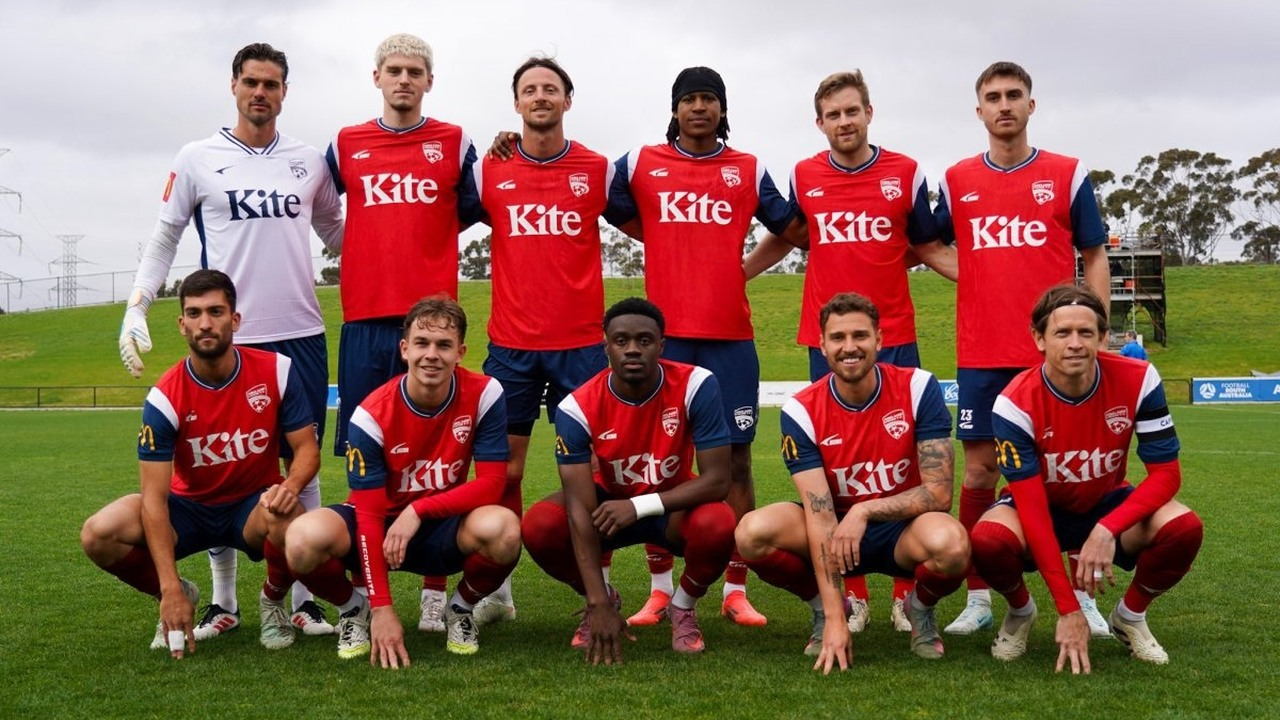 Adelaide United-Spieler posieren gemeinsam in roten Trikots