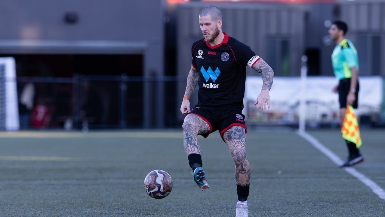 En Sydney United-fodboldspiller bærer bolden under en kamp