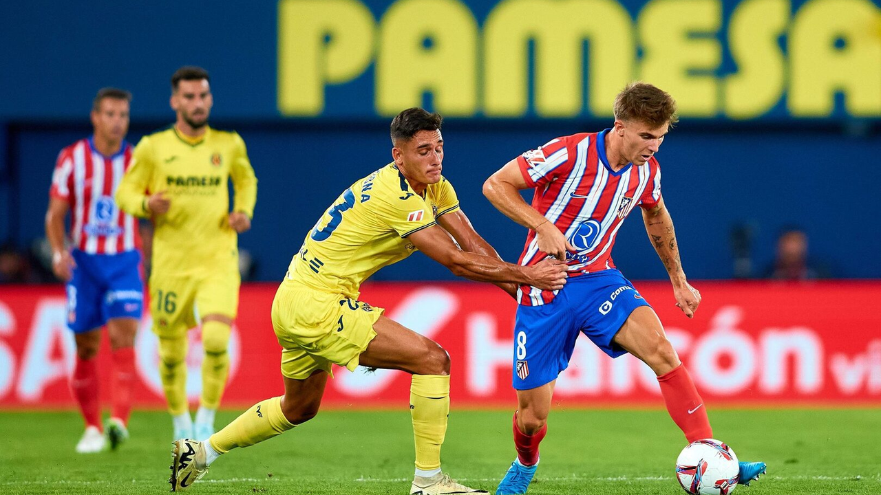 Jugadores del Atletico Madrid y del Villarreal compiten por el balón