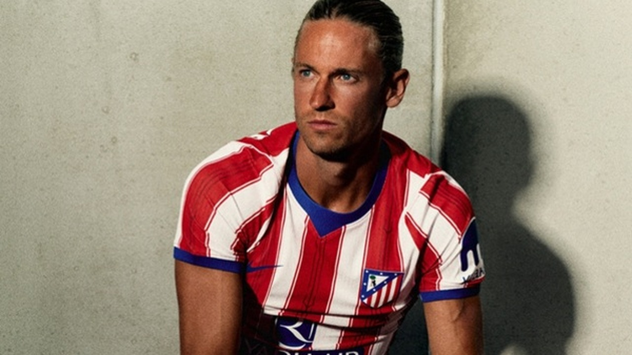Atletico Madrid 선수가 클럽 홈 셔츠를 입고 앉아 있다