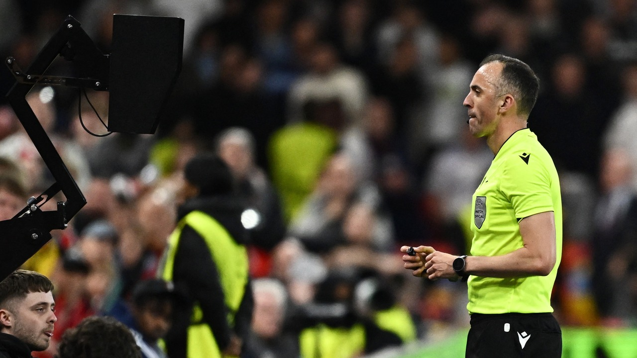 Un árbitro de fútbol muestra una tarjeta durante un partido